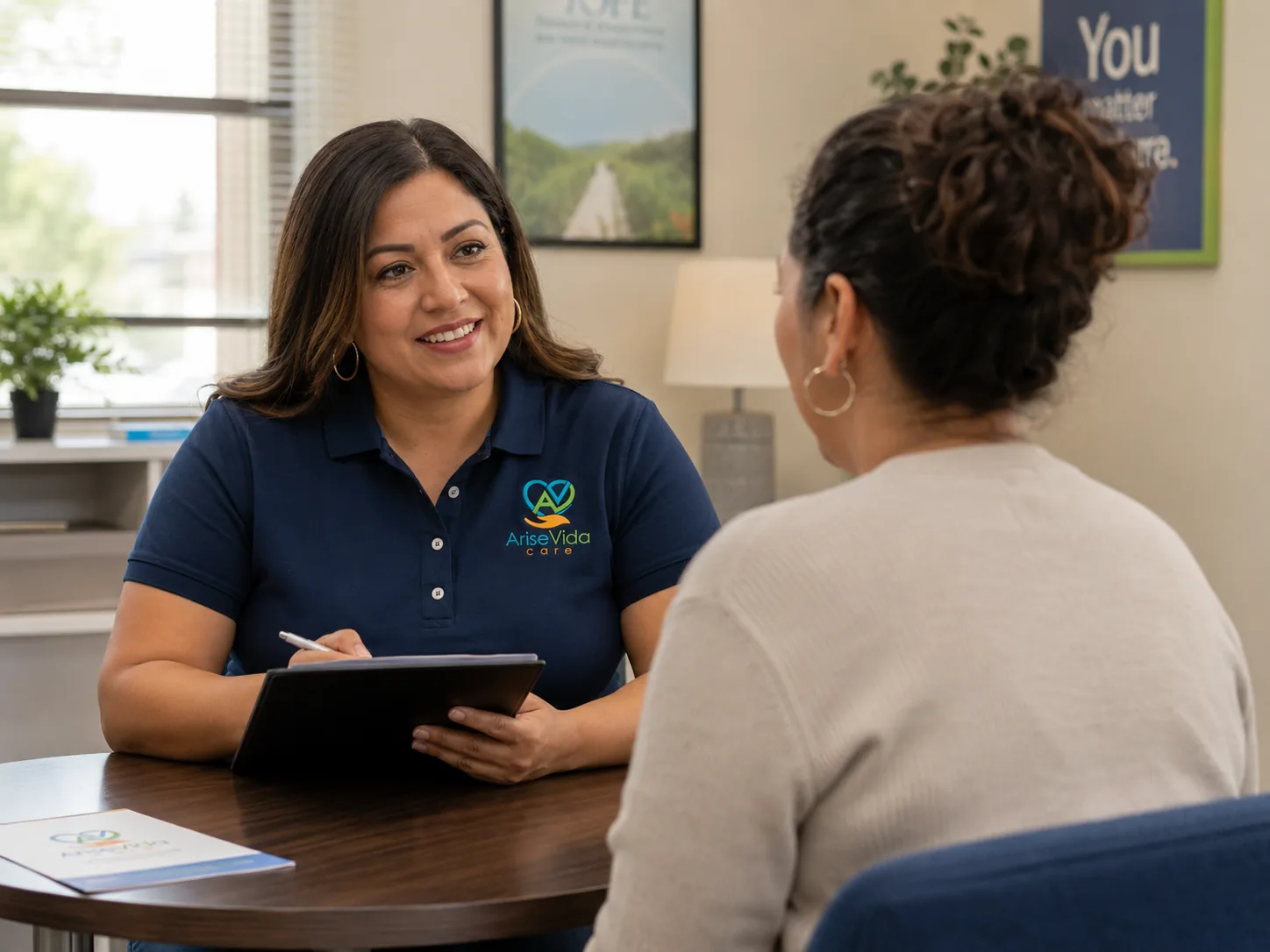 An AriseVida Care admissions team member listening to an adult during an intake conversation.